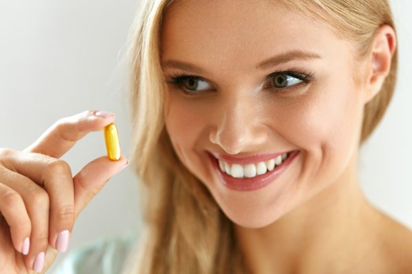 Blonde woman taking a nutritional supplement or vitamin